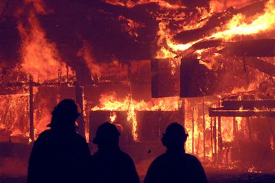 Firefighters look on as fire engulfs the Lodge