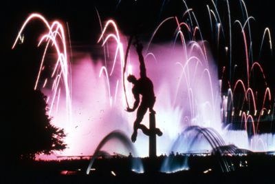 The Rocket Thrower silhouetted against Fountains and Fireworks