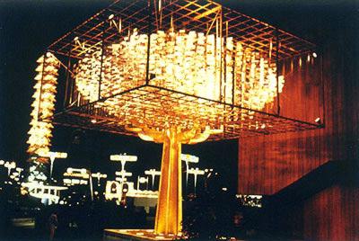 2.2 million dollar money tree, made up of different foreign currencies encased in plastic, alongside American Express (at night)